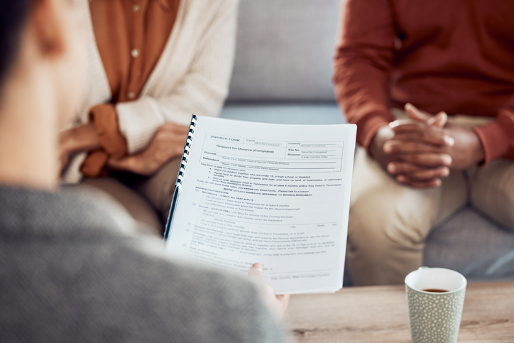 lawyer going over document with divorcing couple