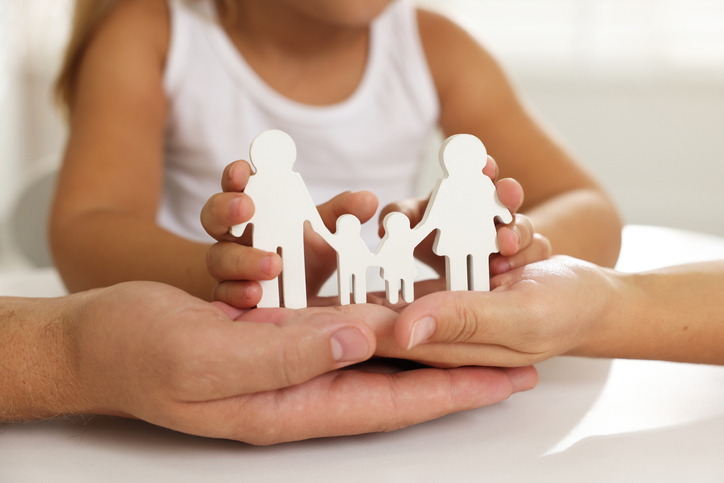 child and parents holding a plastic family cutout